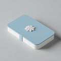 Caja plana para tarjeta regalo impresa en 3D en PLA blanco y azul claro con pomo de copo de nieve. Imagen ilustrativa generada con IA; la pieza real impresa puede variar ligeramente.