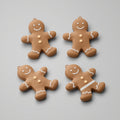 Pack de cuatro galletas de jengibre articuladas impresas en 3D en PLA marrón con detalles blancos. Imagen ilustrativa generada con IA; la pieza real impresa puede variar ligeramente.